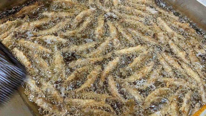 油で揚げられる岩魚の唐揚げ
