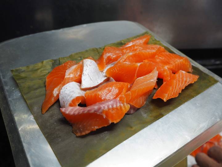 職人が丁寧にニジマスを昆布で締める様子